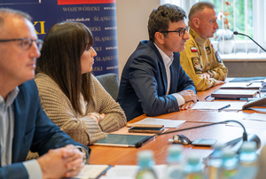 na zdjęciu osoby siedzące za stołem