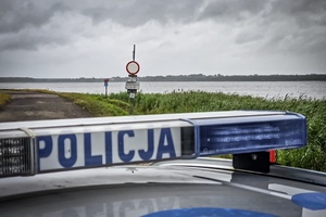 na zdjęciu policyjny neon i w oddali rzeka