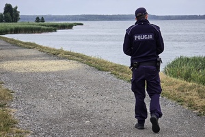 na zdjęciu policjant na ścieżce przy akwenie