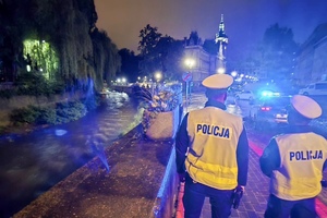 na zdjęciu policjanci na chodniku przy rzece