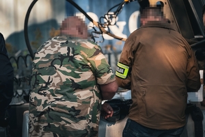 Na zdjęciu ujęty nieumundurowany policjant z zatrzymana osobą