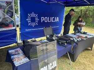 Na zdjęciu widoczne jest policyjne stoisko, na którym znajduje się policyjne wyposażenie