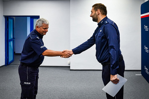 Na zdjęciu widoczny podinspektor Marek Gadziński, który podje dłoń nowemu Zastępcy Naczelnika Wydziału Postępowań Administracyjnych Komendy Wojewódzkiej w Katowicach - komisarzowi Pawłowi Szasakowi.