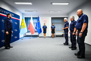 na zdjęciu widoczny jest nowy Zastępca Naczelnika Wydziału Postępowań Administracyjnych Komendy Wojewódzkiej w Katowicach - kom. Pawła Szasaka, który stoi przed Szefem śląskich policjantów - nadinspektorem Mariuszem Krzystyniakiem, w towarzystwie swoich zastępców - inspektora Jacka Stelmacha oraz podinspektora Marka Gadzińskiego