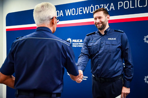 Na zdjęciu widoczny jest Szef śląskich policjantów - nadinspektor Mariusz Krzystyniak, który podje dłoń nowemu Zastępcy Naczelnika Wydziału Postępowań Administracyjnych Komendy Wojewódzkiej w Katowicach - komisarzowi Pawłowi Szasakowi.