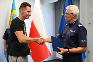 komendant śląski policji wręcza podziękowania wyróżnionemu mężczyźnie