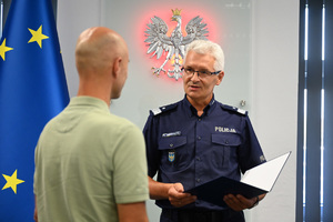 komendant śląski policji wręcza podziękowania wyróżnionemu mężczyźnie