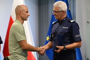 komendant śląski policji wręcza podziękowania wyróżnionemu mężczyźnie