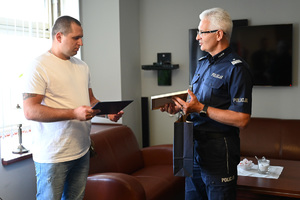 komendant śląski policji wręcza podziękowania wyróżnionemu mężczyźnie