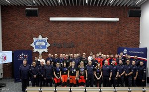 Na zdjęciu widnieją uczestnicy finału ogólnopolskich mistrzostw Policji w ratownictwie medycznym na tle ściany z cegły