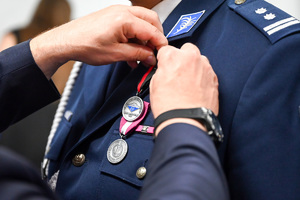 Zdjęcie przedstawia medal zawieszony na policyjnym mundurze