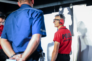 na kolorowym zdjęciu widoczny funkcjonariusz Policji podczas jednej z konkurencji zawodów Dzielnicowy Roku 2025 wraz z sędzią zawodów