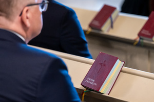 mężczyzna siedzi w ławce w kościele