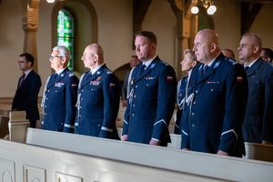 policjanci w mundurach galowych stoją w ławie kościelnej
