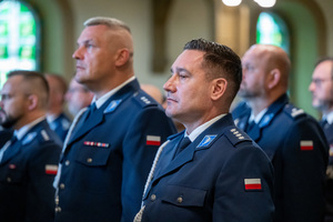 policjanci w mundurach galowych siedzą w ławie kościelnej
