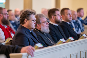 duchowni siedzą w kościelnej ławie
