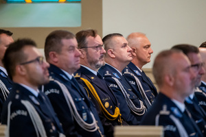 policjanci w mundurach galowych siedzą w ławie kościelnej