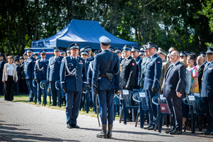 dowódca uroczystego apelu składa meldunek komendantowi, w tle policjanci w mundurach galowych i zaproszeni goście