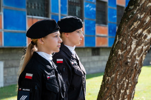 uczennice z klasy mundurowej stoją w mundurach przy budynku komendy