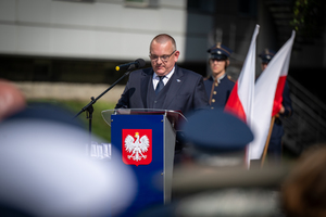 mężczyzna w garniturze stoi przy mównicy