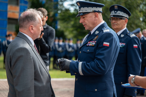 komendant wręcza medal mężczyźnie w garniturze
