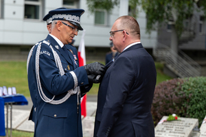 policjant przypina medal mężczyźnie w garniturze
