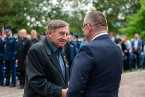 mężczyzna w garniturze podaje rękę drugiemu mężczyźnie w garniturze