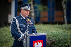 komendant w mundurze galowym przy mównicy