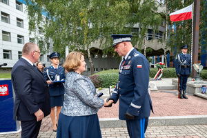 Komendant w mundurze galowym podaje rękę kobiecie