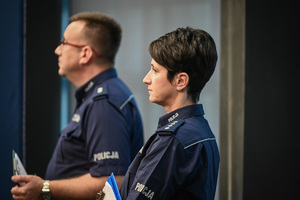 umundurowana policjantka i policjant stoją w auli