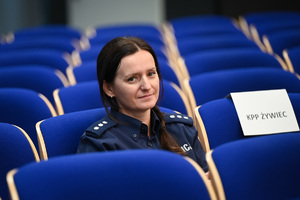 umundurowana policjantka siedzi na krześle w auli