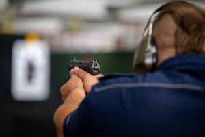 Zdjęcie policjanta trzymającego broń palną