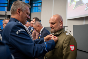 Zdjęcie przedstawia moment przyznania medali