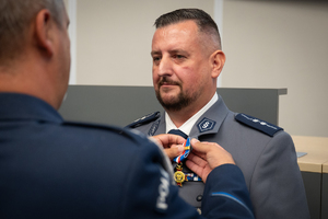 Zdjęcie przedstawia moment przyznania medali