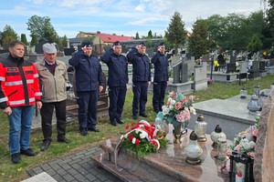 Naczelnik Wydziału Doboru i Szkolenia Komendy Wojewódzkiej Policji w Katowicach, wspólnie z Komendantem Powiatowym Policji w Będzinie, Pierwszym Zastępcą Komendanta Powiatowego Policji w Zawierciu i umundurowanym policjantem oddają honor poległemu sierż. Grzegorzowi Załodze. Na zdjęciu również ojcem poległego policjanta oraz przedstawiciel pogotowia ratunkowego.