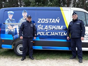 Na zdjęciu Zastępca Komendanta Wojewódzkiego Policji oraz Naczelnik Wydziału Doboru i Szkolenia, w tle promocyjny samochód śląskiej Policji z napisem zostań jednym z nas.
