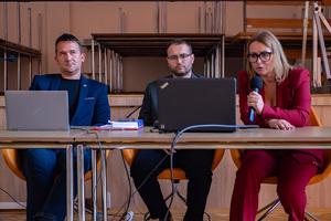 zdjęcie przedstawia trzy osoby w trakcie prezentacji.