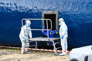zdjęcie przedstawia policjantów w ochronnych kombinezonach dokonujących oględzin na miejscu katastrofy w trakcie ćwiczeń.