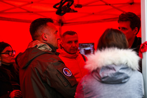 zdjęcie przedstawia osoby w trakcie rozmowy pod namiotem służb.