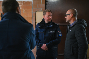 zdjęcie przedstawia policjanta rozmawiającego z innym mężczyzną.