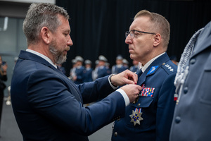 wręczenie medalu nagrodzonemu policjantowi