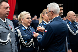 Komendant Wojewódzki Policji w Katowicach przypina medal do munduru nagrodzonej policjantce