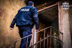 policjant dokonujący kontroli pustostanu