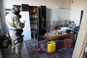 policjant w masce gazowej w pokoju z wieloma naczyniami