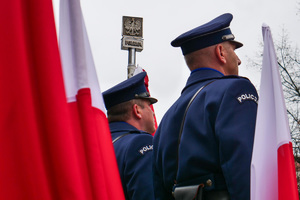 umundurowani policjanci na tle flagi RP