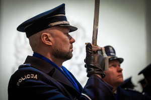 umundurowani policjanci, z których jeden trzyma szablę w ręku