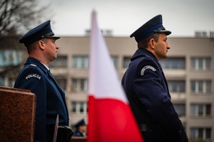 umundurowani policjanci przy fladze