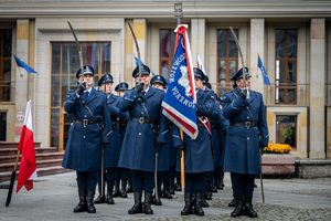 umundurowani policjanci z szablami i sztandarem przy fladze RP