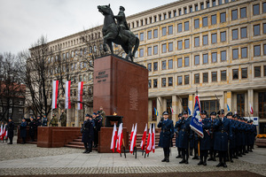 umundurowani policjanci przy flagach oraz pomniku Piłsudskiego