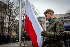 żołnierz obok flagi Polski